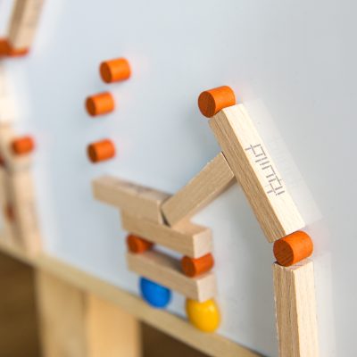 Close-up of an 'ibuild' model from a team building activity. Wooden pieces and connectors form a structure, highlighting the importance of precision, communication, and teamwork in the challenge. thumbnail