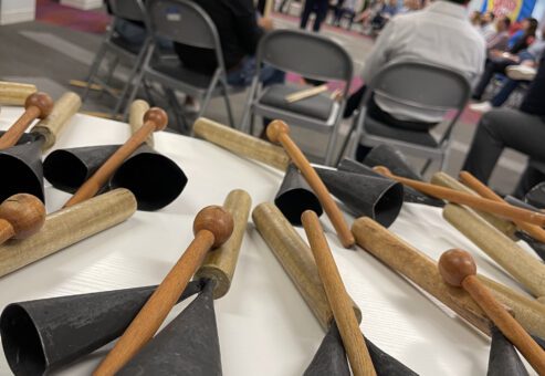 Close-up of cowbells and drumsticks on a table, ready for use in a BeatsWork team building drumming session.