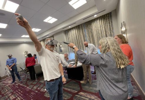 articipants wearing VR headsets collaborate in The Infinite Loop team building event, engaging in hands-on problem-solving tasks that require strong communication and teamwork.