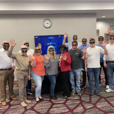 A group of participants pose for a group photo during The Infinite Loop team building event, wearing VR headsets after completing their collaborative virtual challenge. thumbnail