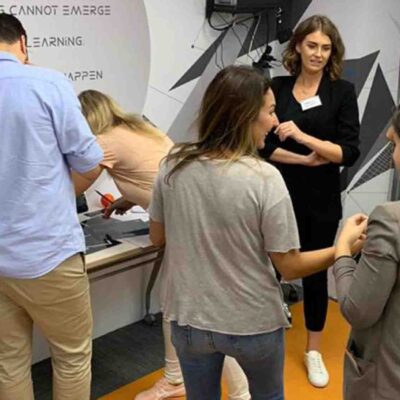Participants engaging in a collaborative VR challenge at The Infinite Loop team building event, with one member wearing a VR headset while others provide input and work together. thumbnail