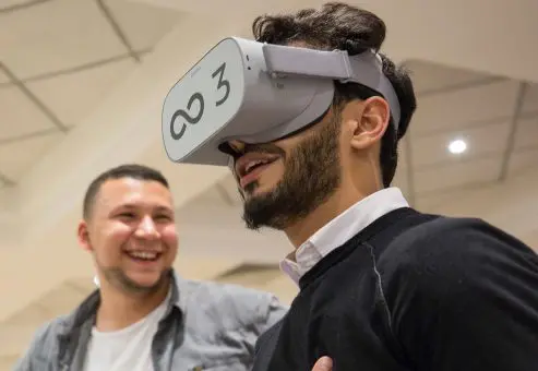 Participant wearing a VR headset during The Infinite Loop team building event, immersed in a virtual world challenge. The activity promotes communication, collaboration, and problem-solving as teams work together to solve challenges in the virtual realm.