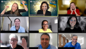 A virtual meeting grid featuring diverse participants smiling and engaging, with one person in the center presenting.