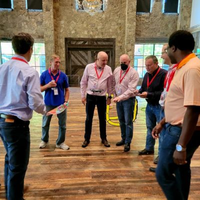 A group collaborates and strategizes during the Game of Drones team building event, working together to maneuver their drone through obstacles. thumbnail