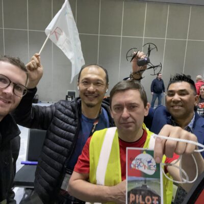 A group of drone pilots proudly display their pilot badge and drone during the Game of Drones team building event, ready for some high-flying fun and competition. thumbnail