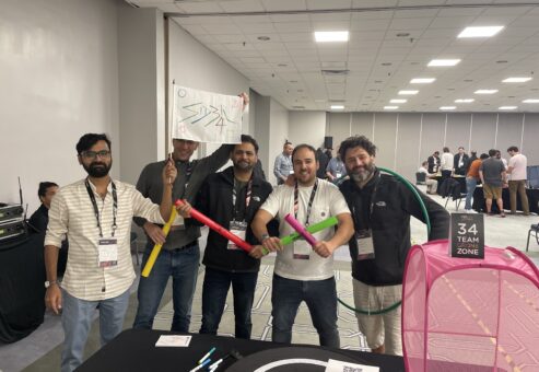 A team stands proudly with colorful drone navigation props during the Game of Drones team building event, ready to take on the challenges ahead.