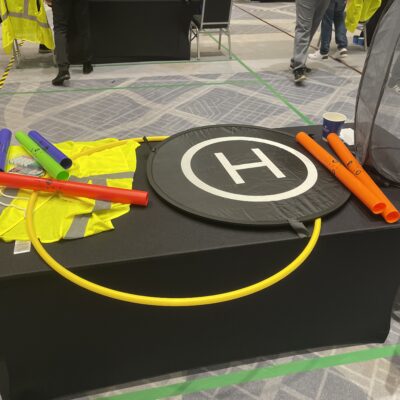 Colorful props, landing pads, and tools are set up for participants to navigate their drones during the Game of Drones team building event. thumbnail