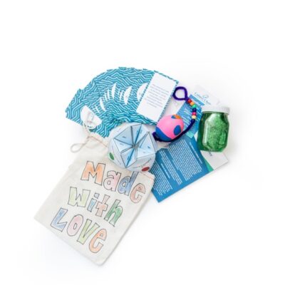 A collection of colorful craft items, including a bag labeled Made with Love, a glitter jar, and various playful objects. thumbnail