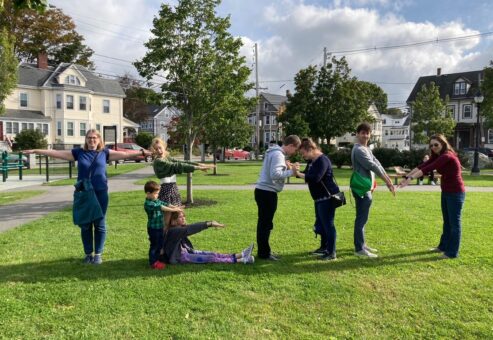 A team creatively posing to spell the word 