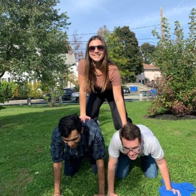 Three participants forming a human pyramid during the Healthcare Heroes scavenger hunt team building program. thumbnail