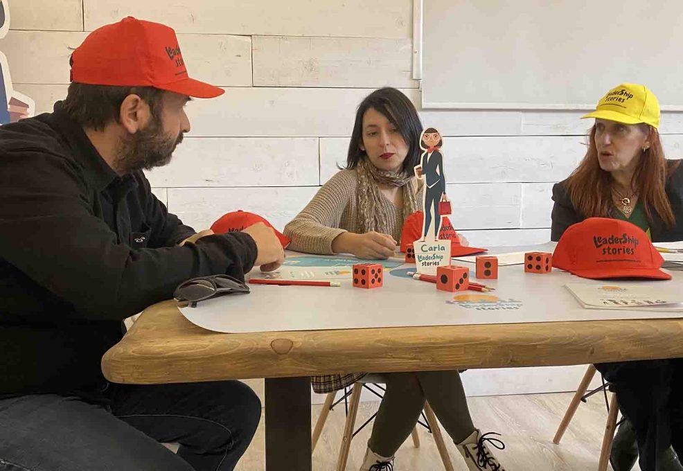 Team members collaborating during the Leadership Stories event, discussing and making strategic decisions while playing the game.