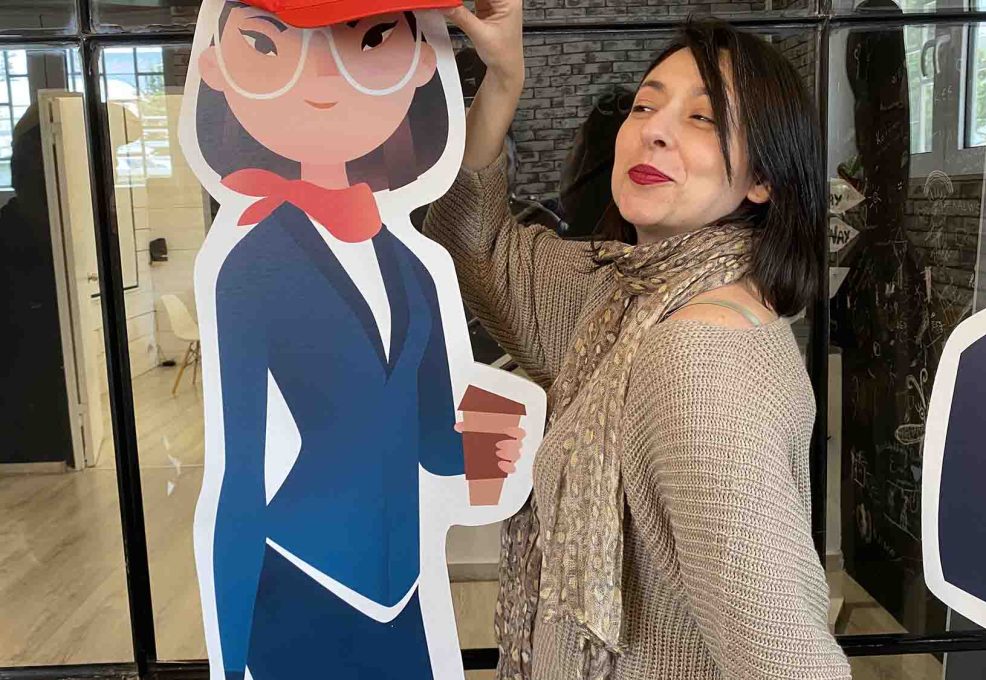 A team member enjoying a fun moment during the Leadership Stories event, posing next to a character cutout from the game.