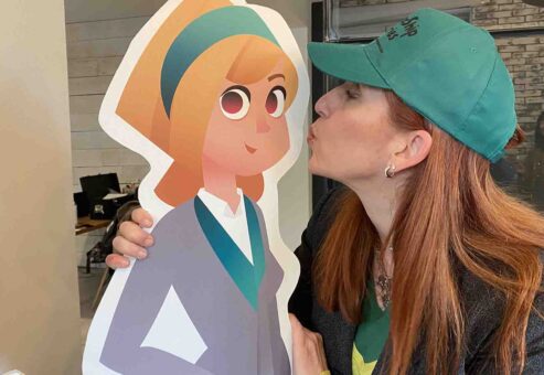 A participant playfully kisses the Leadership Stories character during a fun moment of the event, engaging in team collaboration and leadership exercises.