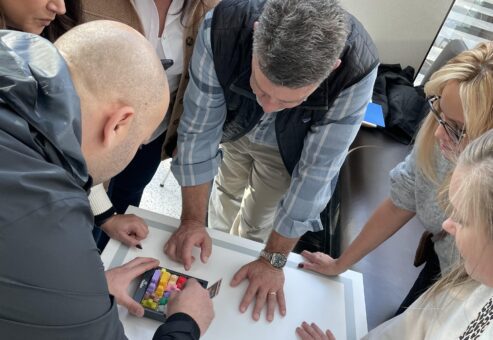 A team collaborating during a puzzle challenge at a team building event, gathered around a table focused on solving a task.