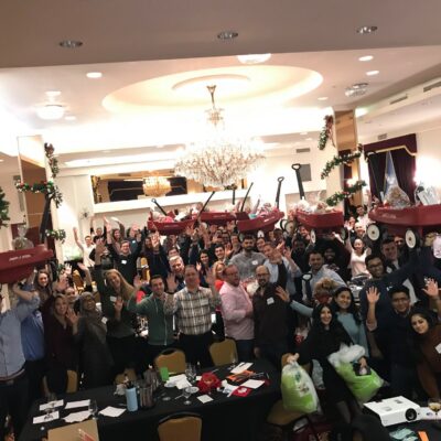 Large group celebrating the completion of wagon-building activity during a festive holiday team building event. thumbnail