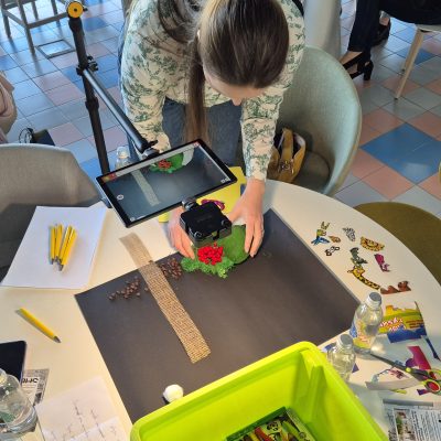 Stop motion animation team building activity. Participants carefully position props and capture frames, collaborating to create a seamless short film while enhancing creativity and communication skills. thumbnail