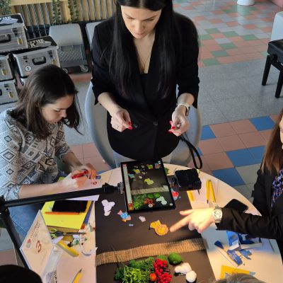 Stop motion animation team building activity. Participants work together to create scenes and adjust props frame by frame, showcasing creativity, teamwork, and collaboration in crafting a short animated film. thumbnail