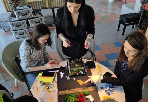 Stop motion animation team building activity. Participants work together to create scenes and adjust props frame by frame, showcasing creativity, teamwork, and collaboration in crafting a short animated film.