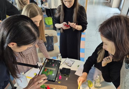 Team building activity centered on stop motion animation. Participants work together to position props and capture frames, fostering creativity, collaboration, and effective communication in storytelling.