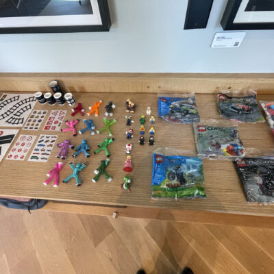 Table setup with small brick building kits, figures, and props ready for a stop motion animation team building activity, encouraging creativity and teamwork. thumbnail
