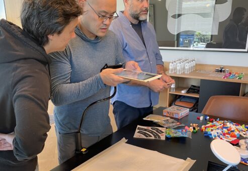 Participants reviewing animation sequences on a tablet during a stop motion animation team building activity, fostering collaboration and creativity.