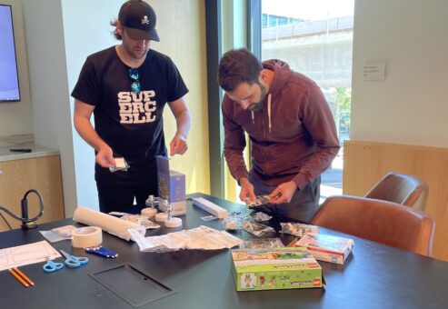 Two participants organizing materials and planning for their stop motion animation project during a team building event.