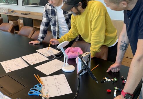 Team members collaborating on a storyboard for a stop motion animation project during a creative team building event.
