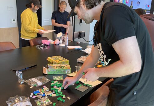Team member assembling small brick pieces for a stop motion animation project during a hands-on team building event.