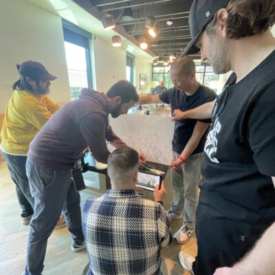 Participants collaborating on a creative stop motion animation project during a team building event, using drawings and props to craft a seamless story. thumbnail