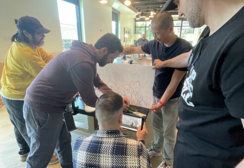 Participants collaborating on a creative stop motion animation project during a team building event, using drawings and props to craft a seamless story.