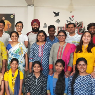A group of men, women, and children from a rural community in India gather together for a group photo, smiling as they celebrate the donations they have received. The diverse group, dressed in colorful traditional and modern attire, reflects the joy and gratitude of the local community benefiting from the donation project. thumbnail