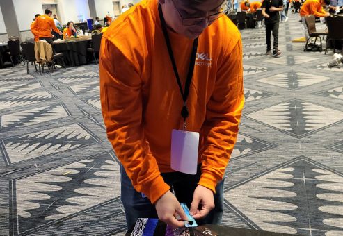 A participant adds creative decorations, such as picks, to go with the guitar donations during the Guitar Build CSR team building program.