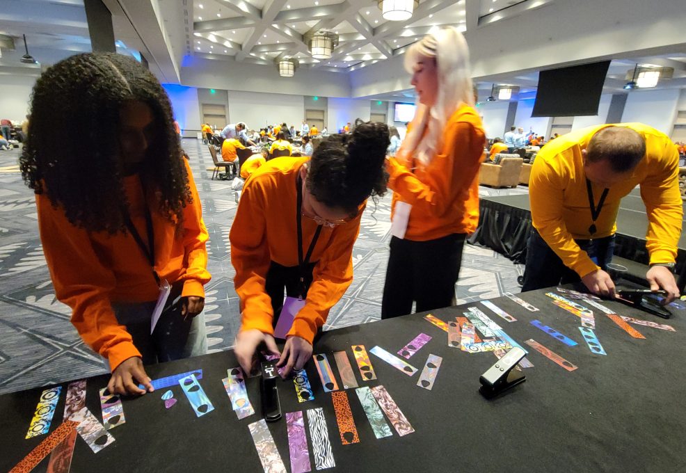 Participant add creative decorations, such as picks, to go with the guitar donations during the Guitar Build CSR team building program.