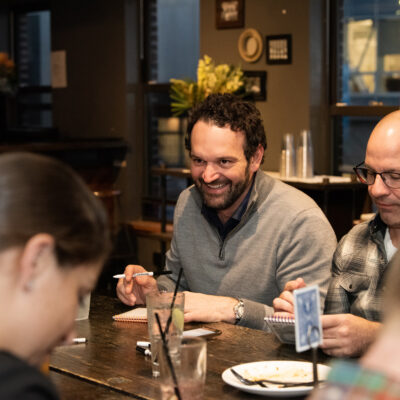 Team members enjoy a lively conversation while participating in a team building networking game at a casual event. thumbnail