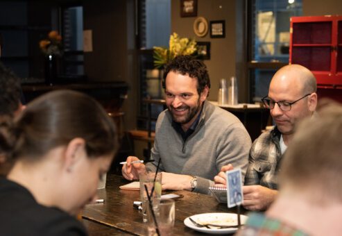 Team members enjoy a lively conversation while participating in a team building networking game at a casual event.