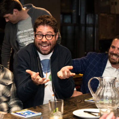 Two team members laugh together while participating in an engaging board game at a team building networking event. thumbnail