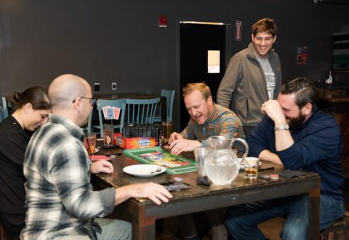 Team members share a moment of laughter while playing a board game during a lively team building networking event.