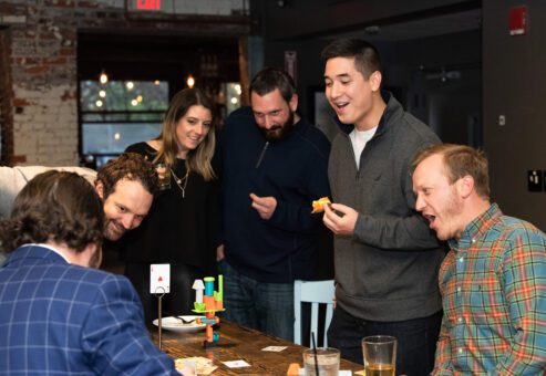 Participants enthusiastically engage in a fun and competitive board game during a team building networking event.