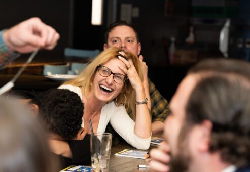 A participant laughs and enjoys the team building game during a fun and engaging networking event, fostering connections through playful interaction.