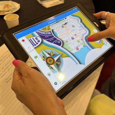 Close-up of a participant using a GPS-enabled tablet during a human skills team building activity. The interactive challenge encourages teamwork, strategic thinking, and problem-solving. thumbnail