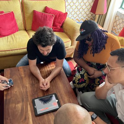 Team building activity focused on human skills training. A group collaborates around a tablet, strategizing and problem-solving to complete a challenge, emphasizing teamwork and critical thinking. thumbnail