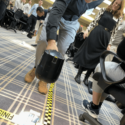 A participant watches intently as their STEM-built car crosses the finish line during the STEM Speedway race at a team building event. thumbnail