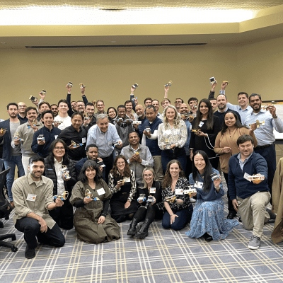Participants pose together in celebration after completing their STEM Speedway race car projects in a team building event. thumbnail