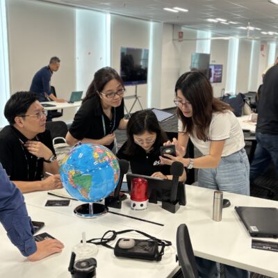 A team collaborates in a team building AI-powered news broadcast challenge, brainstorming and working together on roles like scriptwriting, research, and production. thumbnail