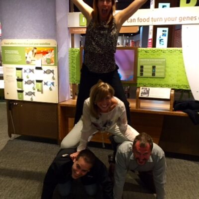 Team members forming a human pyramid during a museum scavenger hunt. This collaborative activity promotes teamwork, fun, and creativity while solving clues and engaging with interactive exhibits. thumbnail