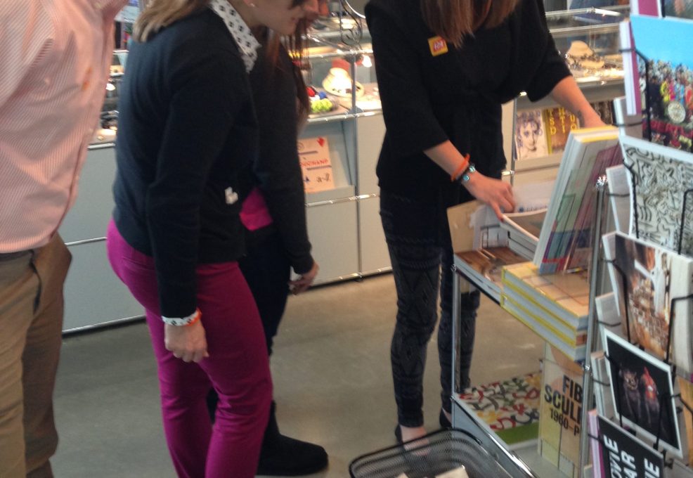 Team members working together during a museum scavenger hunt, collaborating to solve clues while engaging with exhibits in a bookshop. This team building activity fosters creativity, teamwork, and problem-solving.