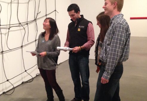 Team engaging in a museum scavenger hunt, analyzing an art exhibit while solving clues. This team building activity encourages collaboration, critical thinking, and cultural exploration.