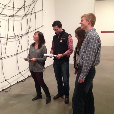 Team engaging in a museum scavenger hunt, analyzing an art exhibit while solving clues. This team building activity encourages collaboration, critical thinking, and cultural exploration. thumbnail