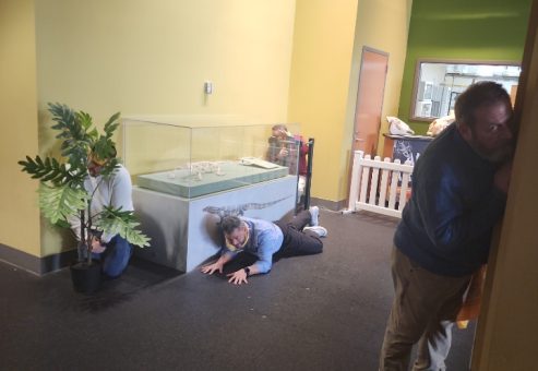 Team members engaging in a fun and interactive museum scavenger hunt. They work together to solve clues, exploring the exhibit while using creative problem-solving and teamwork.