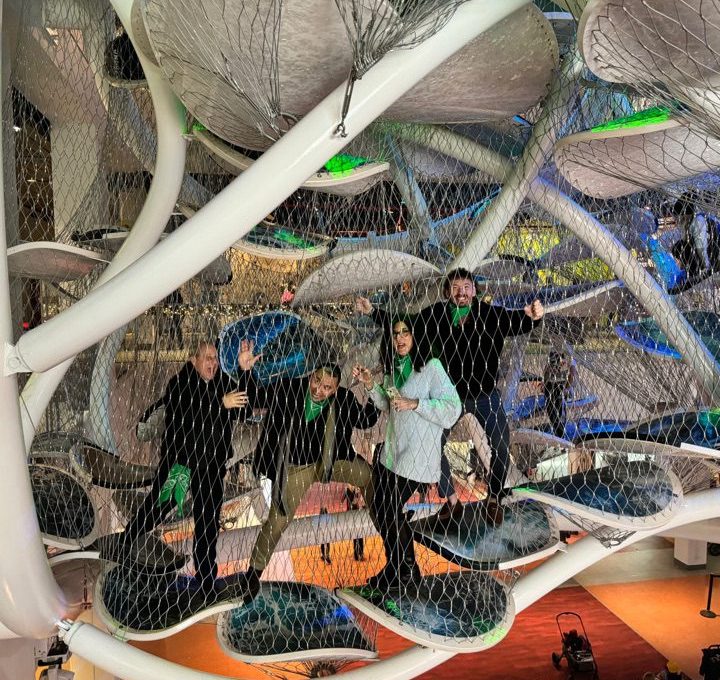 Team participating in a museum scavenger hunt, exploring an interactive climbing exhibit. This team building activity combines culture, problem-solving, and adventure in a fun and engaging experience.
